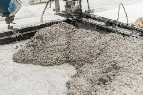 Świeży beton wylewany z betoniarki. Z czego jest cement? Z wapienia i gliny, które po wypaleniu i zmieleniu tworzą spoiwo.