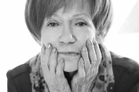 Portret Marii Czubaszek, z dłońmi podpartymi na policzkach. Jej spojrzenie przywodzi na myśl jej słynne maria czubaszek cytaty.