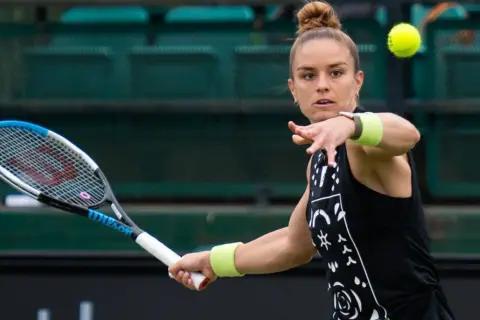 Maria Sakkari w akcji, uderza piłkę rakietą. Skupiona na grze, gotowa do zwycięstwa.