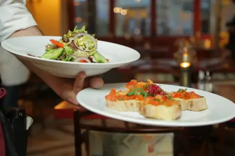 Lekki poczęstunek po pogrzebie: świeża sałatka i bruschetta z pomidorami.