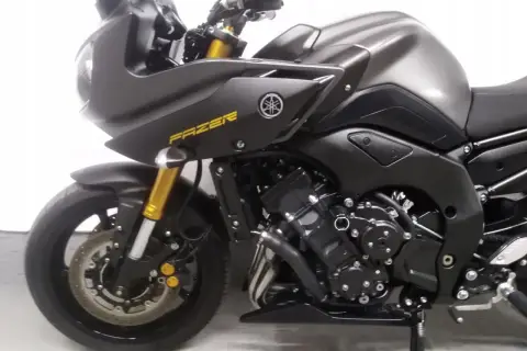 Ciemnoszary motocykl Yamaha FZ8 z żółtym napisem "FAZER" na owiewce. Widoczny przedni widelec i koło.
