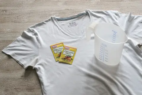 Weiße T-Shirts mit gelben Achselflecken? Zitronensäure und ein Messbecher liegen bereit, um die Flecken zu entfernen.