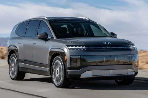 Szary Hyundai Ioniq 9 jedzie po pustynnej drodze. Futurystyczny design z charakterystycznymi światłami.