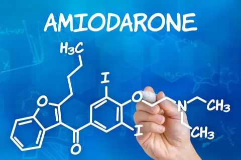 Ręka pisze wzór chemiczny amiodaronu. Lek ten stosuje się na arytmie serca.