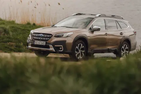 Brązowy Subaru Outback 2025 zaparkowany nad jeziorem, gotowy na przygodę.