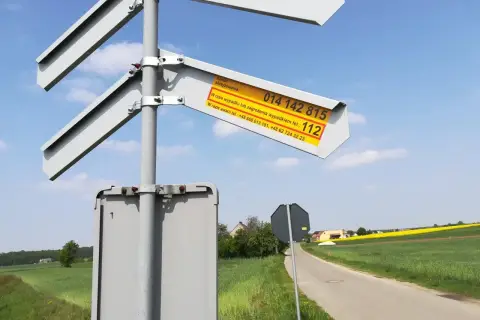 Znak informuje o numerze skrzyżowania i numerach alarmowych w razie wypadku lub awarii na przejeździe kolejowym.
