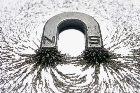 Podkowa magnetyczna z przyciągniętymi drobinkami ferromagnetyków, tworzącymi linie pola magnetycznego.