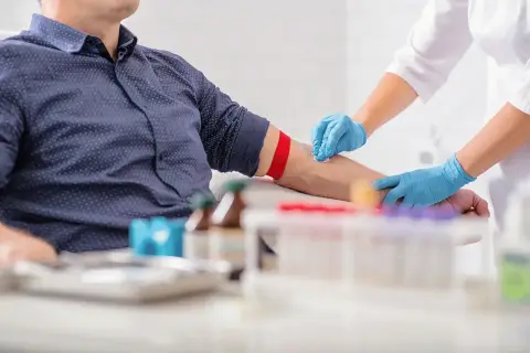 Pielęgniarka pobiera krew od pacjenta, co może pomóc w diagnostyce, co wypłukuje żelazo z organizmu.