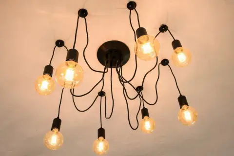 Nowoczesna lampa sufitowa z wieloma żarówkami. Dowiedz się, jak przesunąć lampę sufitową bez kucia, wykorzystując jej elastyczną konstrukcję.