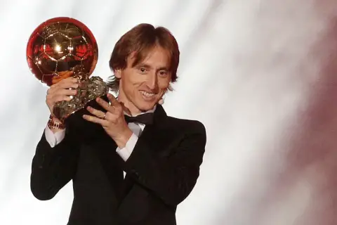 Luka Modrić z dumą prezentuje swoją Złotą Piłkę, symbol triumfu i niezapomnianego roku w karierze.