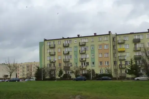 Bloki mieszkalne w Łodzi, z widocznym szyldem "SPRZEDAM". Ceny mieszkań w Łodzi mogą być różne, ale te budynki wyglądają na typowe dla osiedli z lat 70.