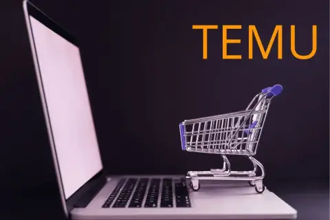 Laptop z małym wózkiem sklepowym na klawiaturze i napisem TEMU. Szybki zwrot pieniędzy po zakupach online.