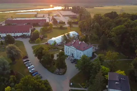 Widok z lotu ptaka na hotel Jakubus z otaczającym go parkiem i stawem w tle.