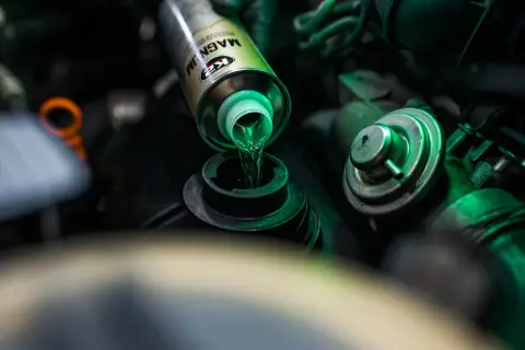 Zielony płyn z puszki K2 Magnum wlewa się do silnika. To doskonała płukanka do silnika, która oczyści go z osadów.