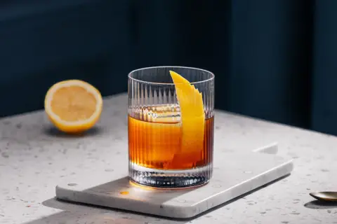 Klasyczne Old Fashioned z odpowiednią kostką lodu i skórką pomarańczy. Idealny drink na wieczór.