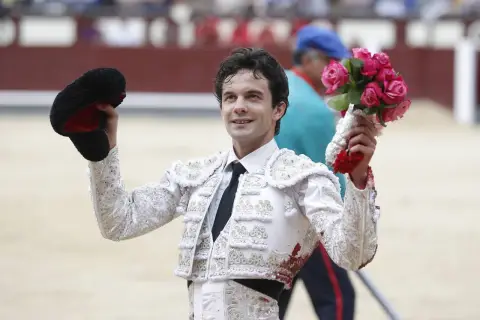 Juan del Álamo, torero, sonríe con un ramo de rosas en la mano y su montera en la otra, tras una faena.