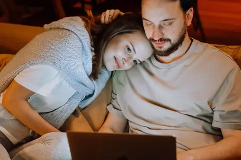 Para spędza czas razem, kobieta opiera głowę na ramieniu mężczyzny. Ich bliskość emanuje spokojem, jak w praktykach tantra.