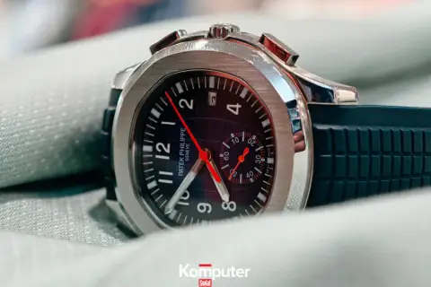 Elegancki zegarek Patek Philippe, model inspirowany stylem Marie Philippe, z czarną tarczą i gumowym paskiem, leży na zielonym materiale.