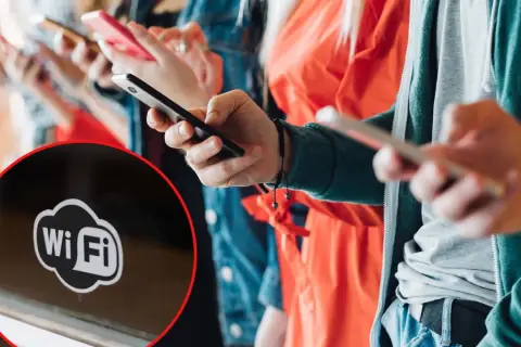 Ludzie korzystają z telefonów, a na pierwszym planie widać symbol Wi-Fi, sugerujący darmowy internet.