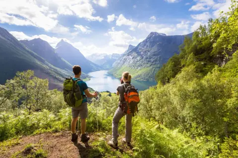 Trekking co to? Dwóch turystów z plecakami podziwia malowniczy fiord i góry.