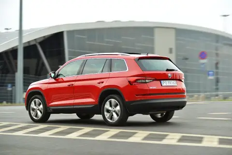 Czerwona Skoda Kodiaq w ruchu. Wiele pozytywnych skoda kodiaq opinie potwierdza jej wszechstronność.