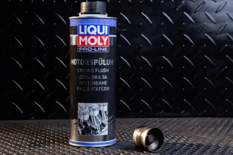 Puszka Liqui Moly Engine Flush, czyli moto doktor do silnika, obok metalowego elementu.