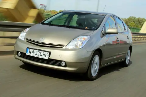 Złoty Toyota Prius 2 jedzie po moście, rejestracja WW 320WE.