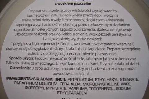 Wazelina kosmetyczna z woskiem pszczelim. Składnik PETROLATUM to wazelina, która tworzy film ochronny, zapobiega wysychaniu skóry i łagodzi podrażnienia.
