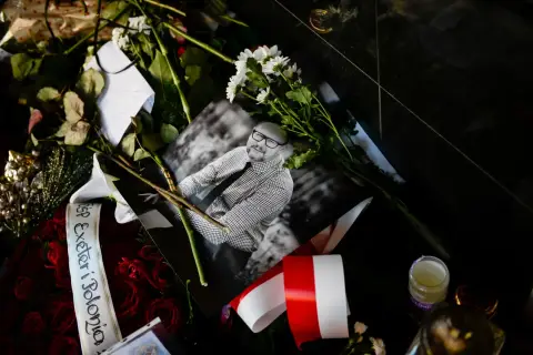 Czarne róże, białe kwiaty i zdjęcie uśmiechniętego mężczyzny. Wstęga z napisem "Exeter Polonia" i polska flaga. Wokół panuje cisza.