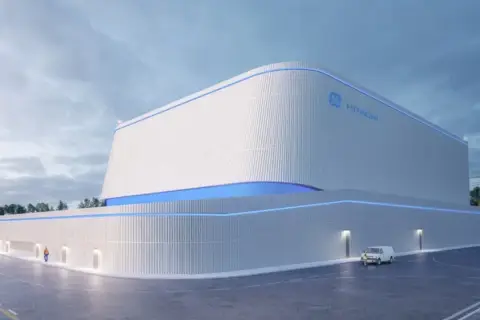 Nowoczesny budynek z logo GE Hitachi, prawdopodobnie elektrownia jądrowa BWRX-300, z niebieskimi akcentami świetlnymi.