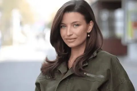 Julia Wieniawa w zielonej kurtce, z rozpuszczonymi włosami i złotą kolczykiem. Ciekawe, ile lat ma Julia Wieniawa?