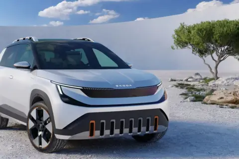 Biały Skoda Enyaq z czarnym dachem i relingami stoi na kamienistym pustkowiu.