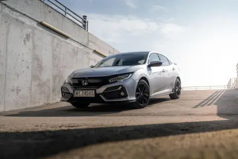 Srebrna Honda Civic 7 na tle betonowej ściany i nieba.