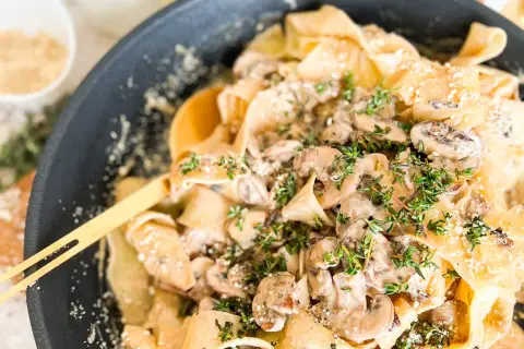 Cremige Pasta mit Pilzen und frischem Thymian, garniert mit Parmesan. Ein köstliches Gericht, das Lust auf mehr macht.