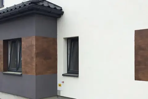 Eleganckie tynki wapienne imitujące drewno zdobią fragmenty nowoczesnego domu.