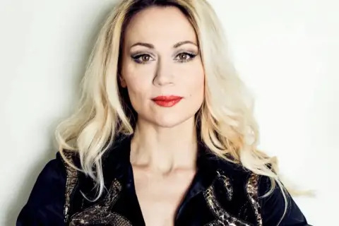 Anna Eriksson, z blond włosami i wyrazistym makijażem, w czarnej, zdobionej kurtce.