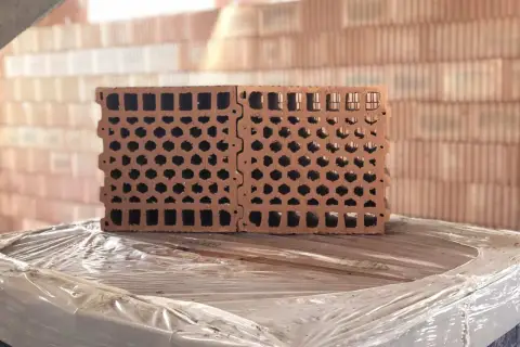 Blocchi forati in laterizio, ideali per l'isolamento acustico, impilati su un bancale.