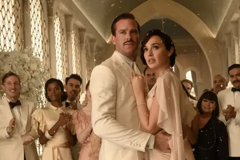 Śmierć na Nilu obsada: Armie Hammer i Gal Gadot w eleganckich strojach, otoczeni przez innych aktorów, podczas uroczystości.
