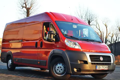 Czerwony Fiat Ducato Maxi zaparkowany na zewnątrz, gotowy do transportu.