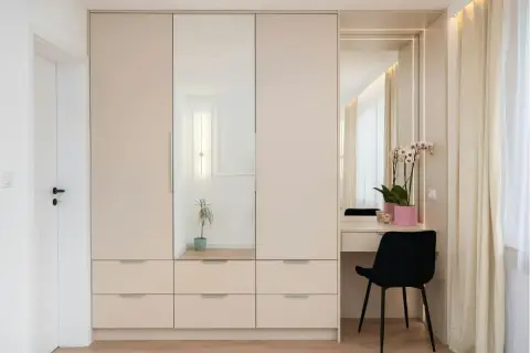 Armadio in laminato chiaro con ante a specchio e zona toeletta. Un modo moderno per rinnovare armadio laminato e creare uno spazio funzionale.