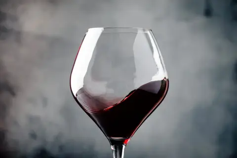 Ein Glas Rotwein wirbelt, erinnert an die tiefen Aromen von Navarra, Spanien.