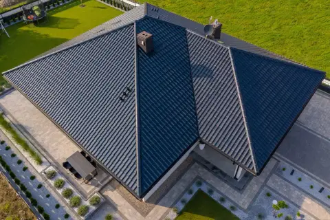 Nowoczesny dom z ciemnym dachem z dachówki ceramicznej. Różne rodzaje dachówek tworzą harmonijną całość.