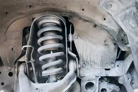 Primer plano de un amortiguador de coche, parte esencial para el confort y la seguridad.