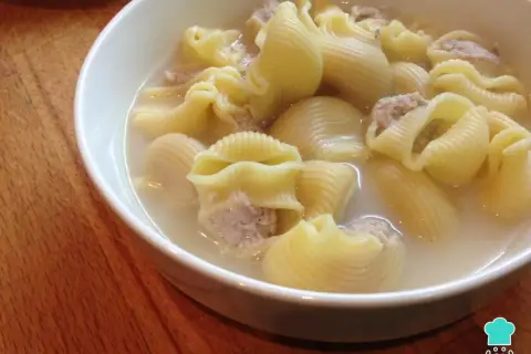 Un tazón de sopa de galets, con pasta grande rellena de carne picada en un caldo sabroso.