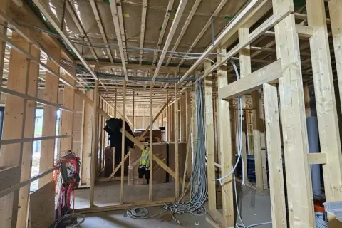 Widoczne jest mocowanie peszla do drewna w konstrukcji budynku. Instalacja elektryczna w trakcie budowy.