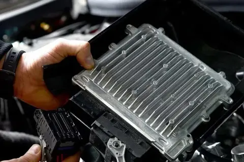 Mechanik wymienia komputer sterujący silnikiem, kluczowy element w procesie jak zwiększyć moc silnika.