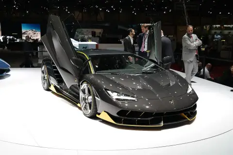 Ciemnoszary Lamborghini z otwartymi drzwiami, żółtymi akcentami. Zastanawiasz się, ile kosztuje Lamborghini? Ten model robi wrażenie!