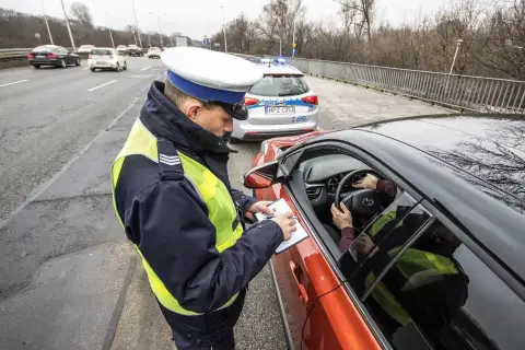 Policjant spisuje mandat. Kierowca zastanawia się, jak się bronić przed art. 97 k.w. w tej sytuacji.