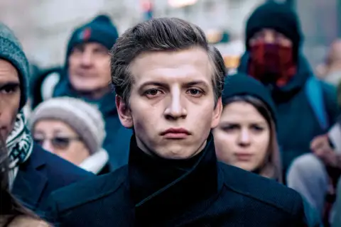 Młody mężczyzna na pierwszym planie, otoczony ludźmi. Sala samobójców obsada.