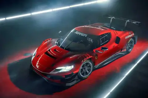 Roter Ferrari 488 GT3 Rennwagen mit großem Heckflügel, beleuchtet von Neonröhren auf rotem Untergrund.